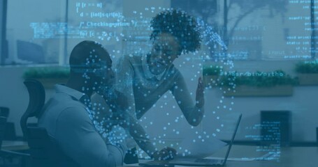 Man focusing on laptop initiating data visuals floating at desk with woman clarifying code segments - Powered by Adobe
