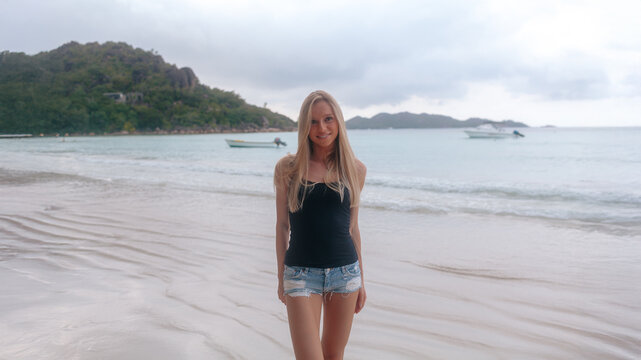 Young attractive blonde girl with perfect sport body in bikini on the tropical summer beach