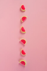 Fruit jelly mixed with sugar on pink background