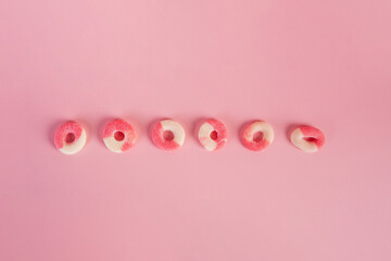 Fruit jelly mixed with sugar on pink background