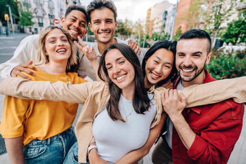 Happy group of friends smiling at camera outside - Diverse young people having fun together on city street - Youth community and people life style concept