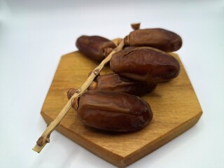 Date palm fruit on serving board. This is the edible, sweet fruit produced by the date palm tree