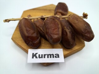 Date palm fruit on wooden serving board. Date palm fruits, or simply dates, are the oval-shaped, sweet, edible fruit of the date palm tree (Phoenix dactylifera)