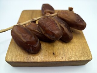 Date palm fruit on serving board. This is the edible, sweet fruit produced by the date palm tree