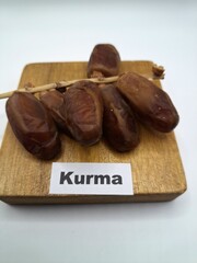 Date palm fruit on wooden serving board. Date palm fruits, or simply dates, are the oval-shaped, sweet, edible fruit of the date palm tree (Phoenix dactylifera)