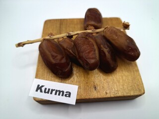 Date palm fruit on wooden serving board. Date palm fruits, or simply dates, are the oval-shaped, sweet, edible fruit of the date palm tree (Phoenix dactylifera)