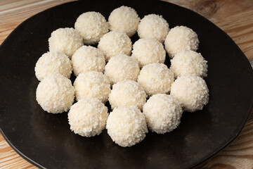 Coconut candies pile, coco ball. White truffle ball, indian ladoo or laddu with sweet cream and coco