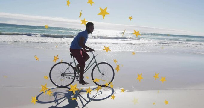 Ad featuring male cyclist starting confetti overlay riding beach bike across wet sand showing stars