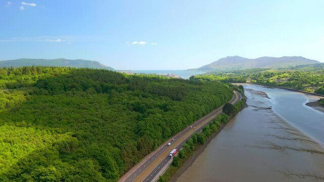 Overhead aerial video of the Newry River and Mourne Mountains in Warrenpoint, County Down, Northern Ireland, UK on a bright and sunny day. Filmed in 4K, 60FPS and with Rec709 color.