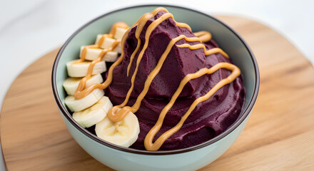 Acai smoothie bowl topped with banana slices and peanut butter drizzle, minimal style.
