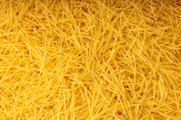 Raw vermicelli textured background, gold soup pasta pattern, small homemade noodles mock up