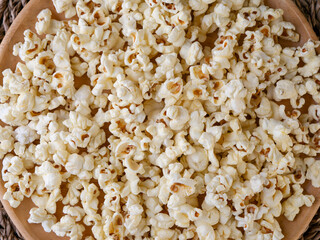Butter salted popcorn on wooden table.