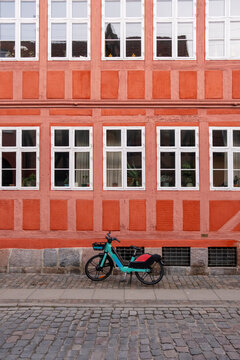 Red Danish facade with parked bicycle, Copenhagen, Denmark, colorful symmetry, Scandinavian architecture and urban transport lifestyle