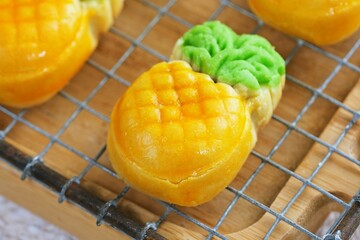 Close up,Indonesian pineapple tart cookies shaped like real pineapples, cooling on a wire rack. A...