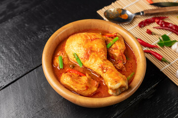 Chicken curry Asian food masala. Traditional cooking healthy food with spices. Arranged on black wooden table background.
