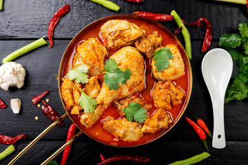 Chicken curry Asian food masala. Traditional cooking healthy food with spices. Arranged on black wooden table background.