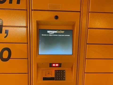 Palma De Mallorca, Spain - June 07, 2025: Amazon locker kiosk with bright yellow exterior, featuring a digital screen for package retrieval and user interaction, showcasing modern delivery solutions
