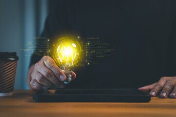 New generation person holding a glowing light bulb in a dark background, symbolizing creativity, innovation, and bright ideas. Business global internet connection application technology.