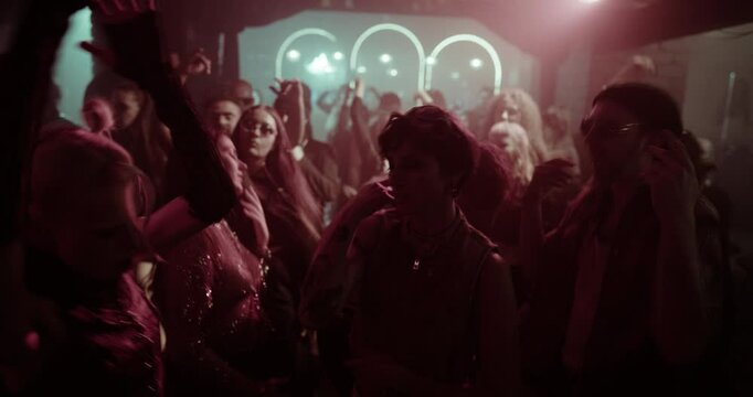 Vibrant Nightclub Scene with Ecstatic People Dancing Under Flashing Neon Lights. High-energy Crowd Moves to Electronic Beats in a Packed, Electric Atmosphere. Portrait of a Female Enjoying the Party