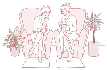 Two friends relax in cozy robes at a spa, enjoying a delightful pampering session with bright smiles