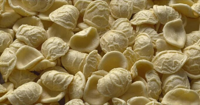 Top view of raw Orecchiette (Apulian little ears) pasta, often used with rapini (broccoli rabe or raab) or regular broccoli. 