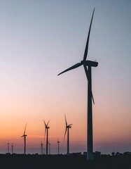 Minimalist Wind Turbines Silhouetted at Dusk. Modern Wind Farm Against a Dramatic Sunset Sky with Soft Muted Colors. Concept for Renewable Energy & Sustainability