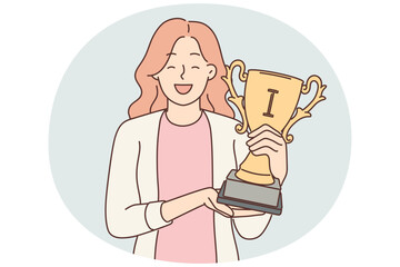 Happy woman with trophy cup in hands smiles and looks at screen showing off achievements