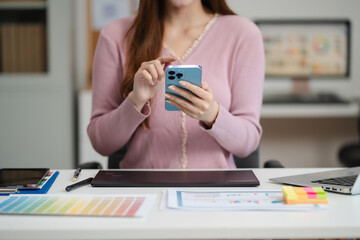 Female coder or developer working  using a smartphone and computer display in problem solving at...
