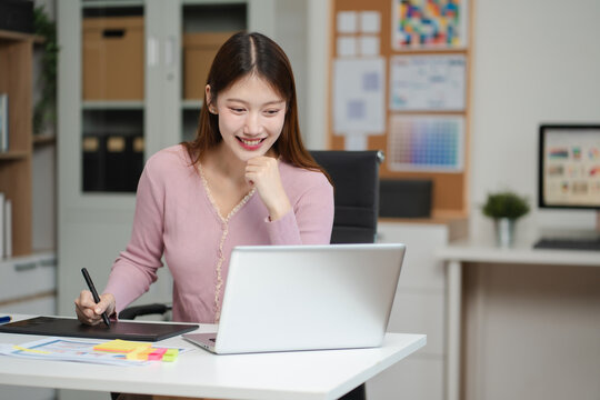 Female coder or developer working  using a smartphone and computer display in problem solving at workplace.