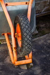 Close-up of an inverted wheelbarrow tire. The wheel has a diamond-shaped tread pattern for...