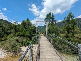 Cycling path running through river valley surrounded by high mountains of Austrian Alps offering scenic nature ride.