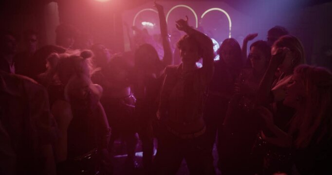 Creative People Move to Energetic Techno Rhythms in a Dark, Color-Drenched Club with Flashing Stroboscopes. Cinematic Slow Motion Footage Celebrating Nightlife, Youth Culture, Freedom and Urban Energy