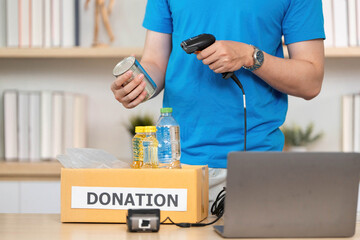 Donation Process. Individual scanning food items for donation in a community support initiative.