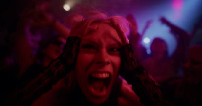 Portrait of a Blonde Female Raver in Full Party Mode, Dancing with Intense, Almost Chaotic Passion. Slow Motion Footage Radiates Rebellious Energy and Nightlife Madness