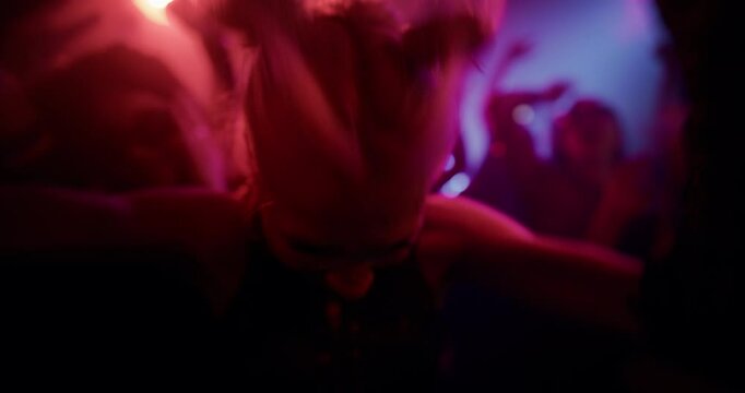 Close Up Portrait of a Blonde Young Woman Dancing Wildly in a Nightclub. Her Intense Gestures and Expression, Aggressive Moves Capture the Raw Energy of Nightlife Euphoria, Hedonism, Craziness