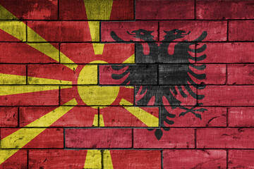 colourful painted big national flag of albania and flag of macedonia on a massive old brick wall background. concept