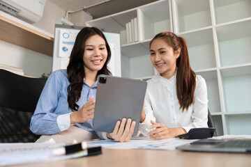 Obraz premium Digital Engagement. Businesswomen reviewing project insights on a tablet in a modern office.