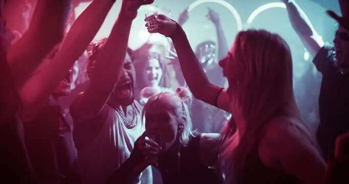 Young Drunk Adults Enjoying a Night Out with Shots in Hand. Friends Drinking Alcohol and Dancing Together in a Diverse Party Scene. Fun, Energetic Moment Full of Nightlife Spirit and Celebration