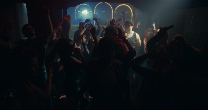 Dynamic Footage of a Crowded Modern Nightclub with Diverse Beautiful Men and Women Dancing to Fast-paced Electronic Music. Lights Pulse in Sync with the Beat. Ecstatic, Liberating and Party Mood