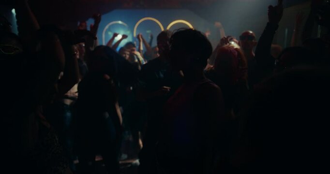 Young Caucasian Female Dancing in a Club. Stylish Clubbers Move to the Rhythm Under Bright LED Lights and Deep Electronic Dance Music. People Dancing and Enjoying Nightlife Energy
