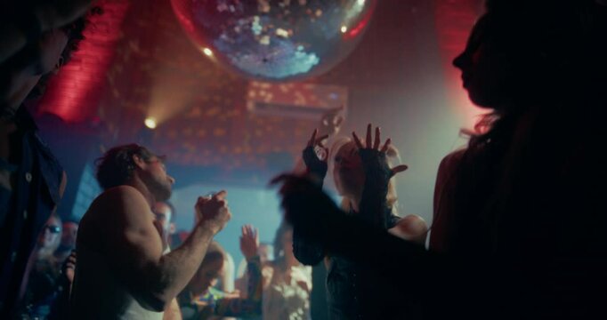 Slow Motion Footage of a Crowded Modern Nightclub with Diverse Beautiful People Dancing to Dynamic Electronic Music. Lights Pulse in Sync with the Beat. Ecstatic, Youthful and Hedonistic Mood