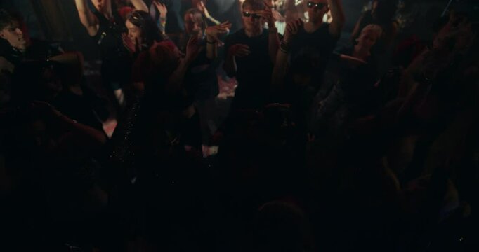 High Angle Slow Motion Footage with People Moving to Energetic Techno Rhythms in a Dark, Color-Drenched Club with Flashing Stroboscopes. Celebrating Nightlife, Youth Culture, Freedom and Urban Energy