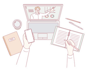 A diligent student fully engaged in online learning, taking detailed notes using both a laptop and notepad