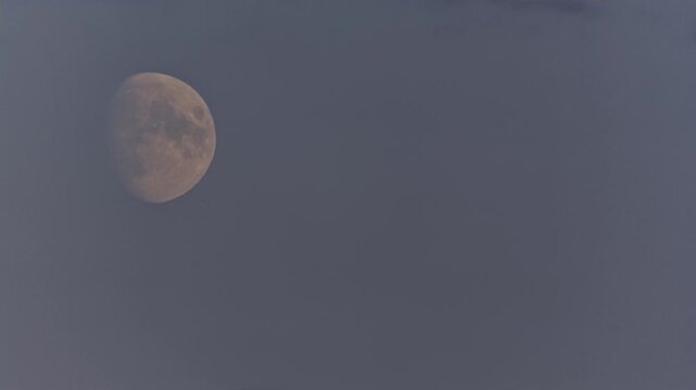 Daylight Moon. The descending Moon among light clouds in daylight at 2am arctic summer. Time Lapse