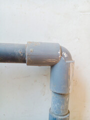 Gray pipe on the white wall. Water pipe on the white wall.