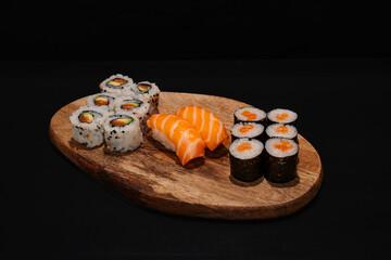 Wooden Platter With Assorted Sushi Rolls on Dark Background