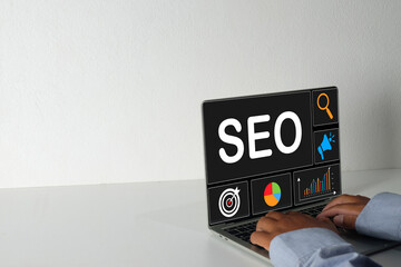 Laptop screen displaying "SEO" with search, target, and analytics icons. Concept for Search Engine Optimization strategy,search analysis, target audience,keyword research,marketing campaign.