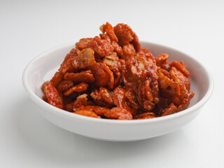 Spicy crunchy snack in white bowl on white background