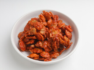 Spicy crunchy snack in white bowl on white background
