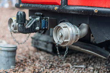 Close-up of an industrial metallic component with bolts, chains, and a hexagonal center cylinder...